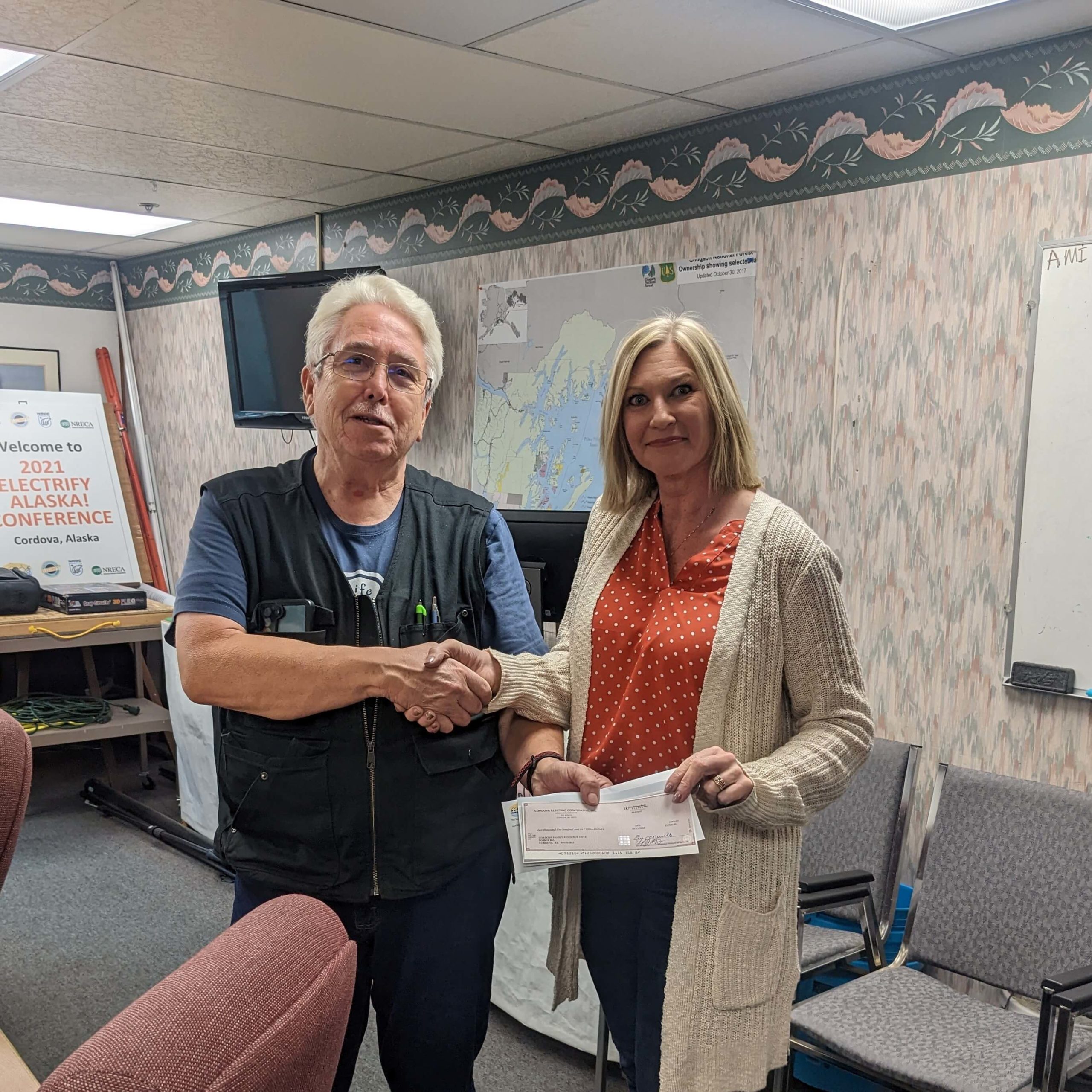 Joe Cook presents check to Nicole Songer for the Cordova Family Resource Center