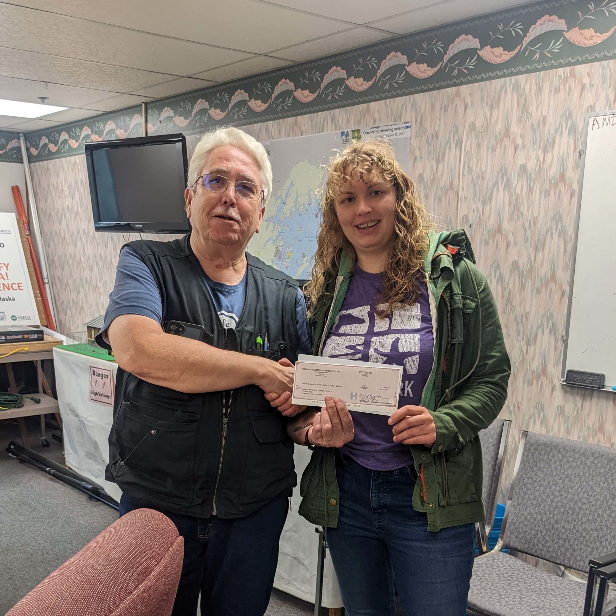 Joe Cook presents check to Shae Bowman for the Copper River Watershed Project